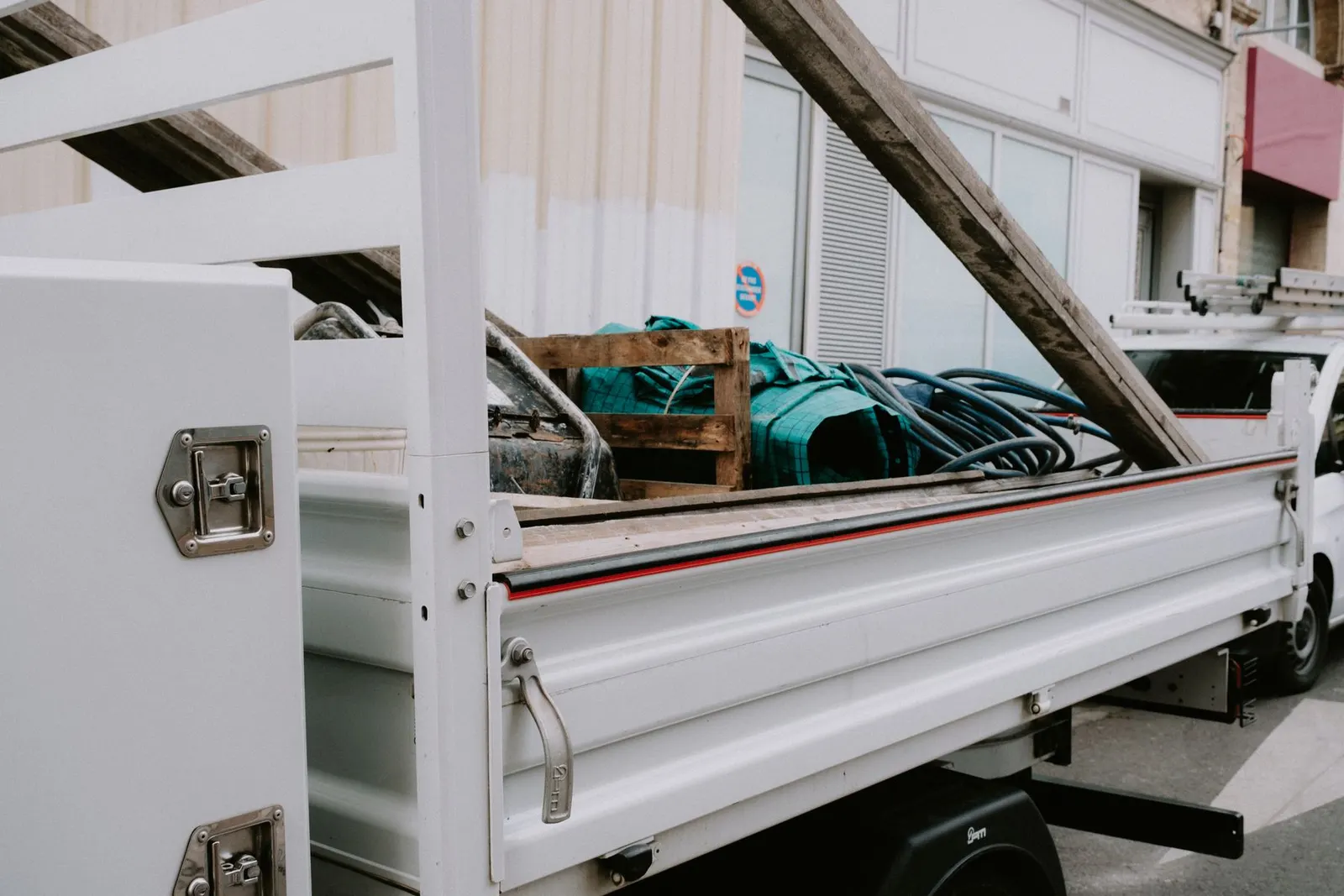 Unbranded utility truck carrying bulky materials for removal