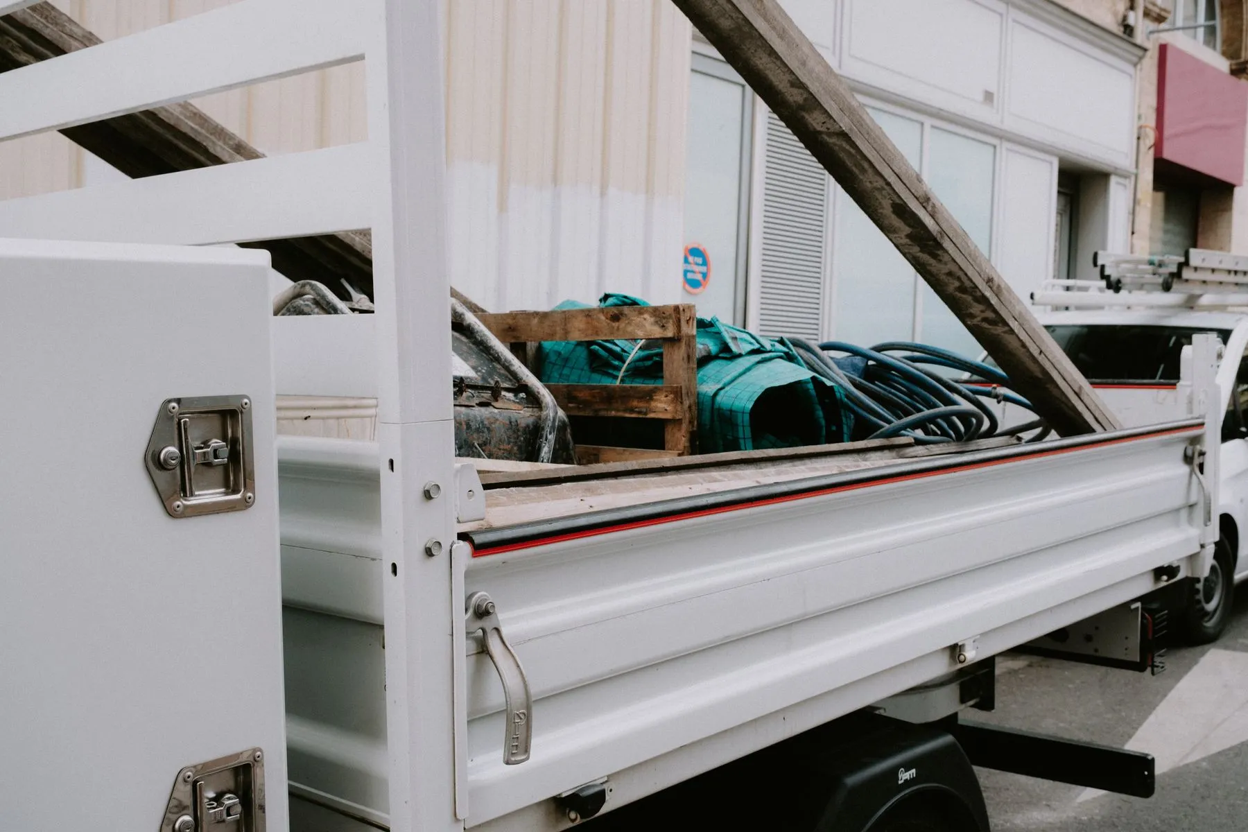 Unbranded utility truck carrying bulky materials for removal