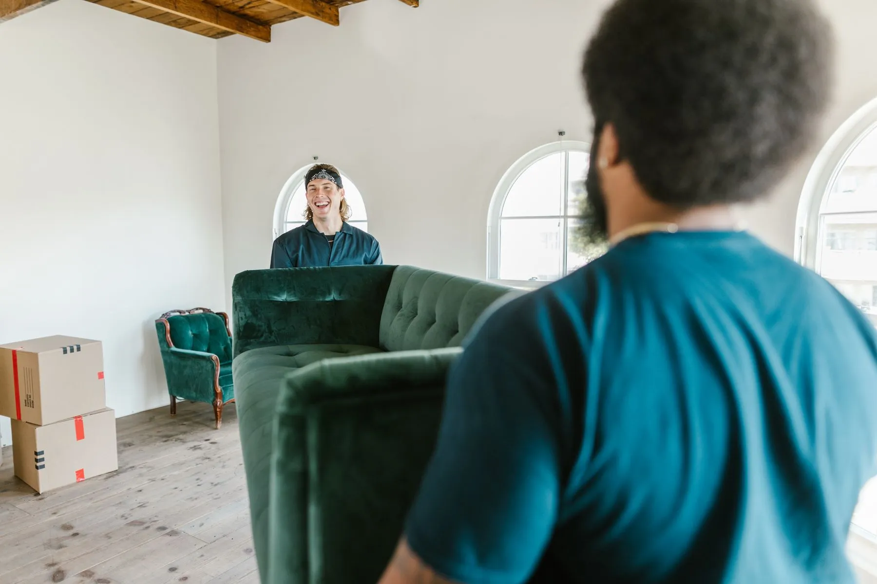 Two movers carrying a sofa in a bright room